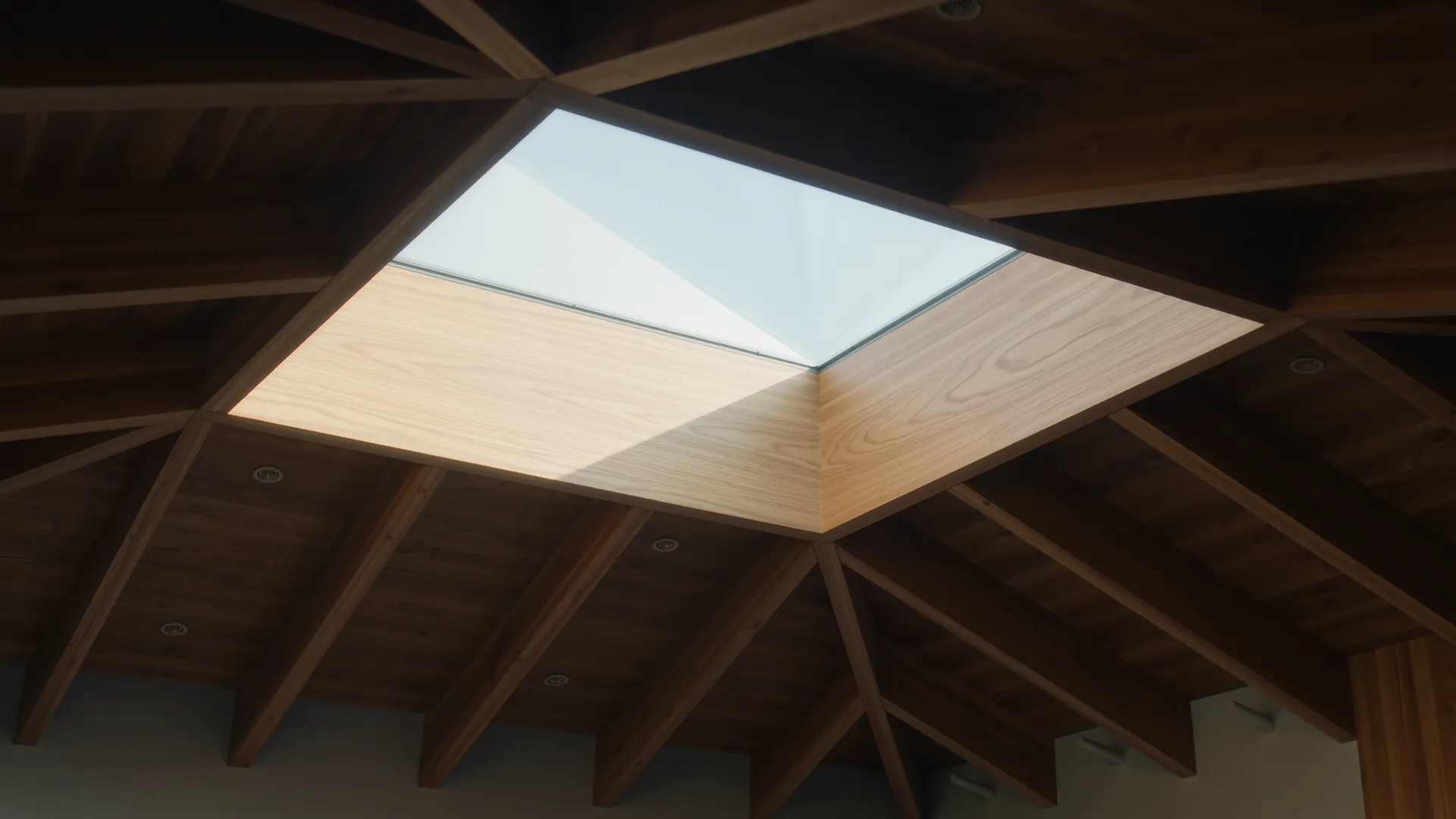Dachstuhl aus hellem Holz von innen, Licht fällt durch ein Dachfenster