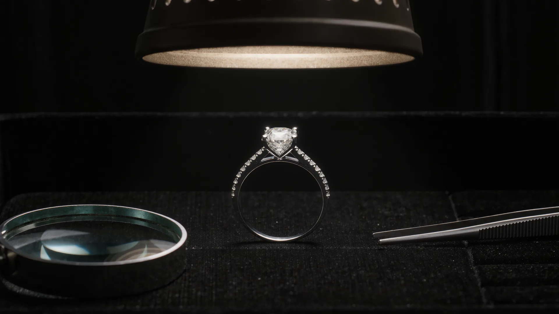 Diamantring auf schwarzem Samt unter der Juwelierlampe, daneben Lupe und Pinzette